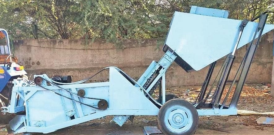 The tractor mounted machine smooths the ground with its edge collects the material on a conveyor belt that spins in the middle dumps the Soil onto the floor and transports